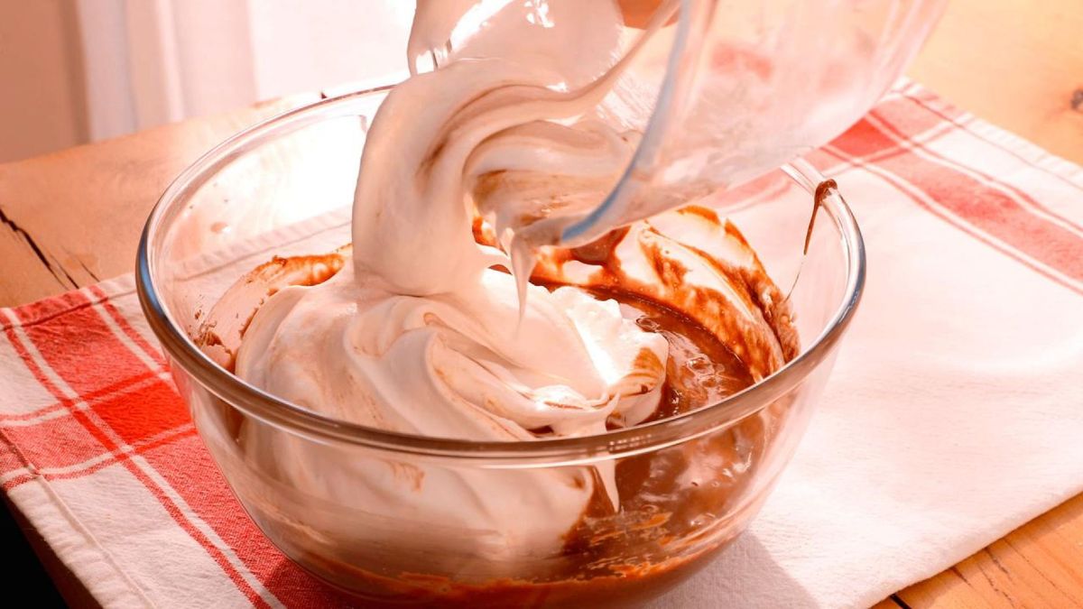 Vierte las claras montadas sobre el chocolate y mezcla suavemente para mantener la esponjosidad