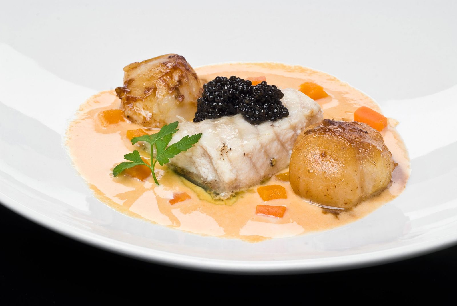 Esturión confitado con vieiras y caviar