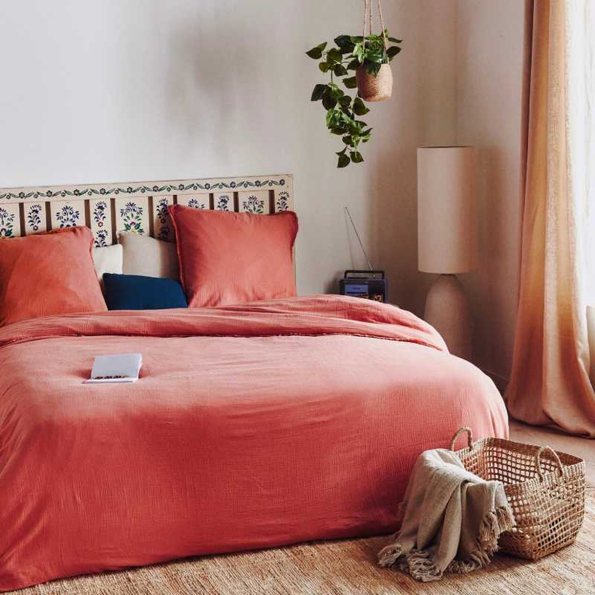 Cama con colcha coral de estilo provenzal.