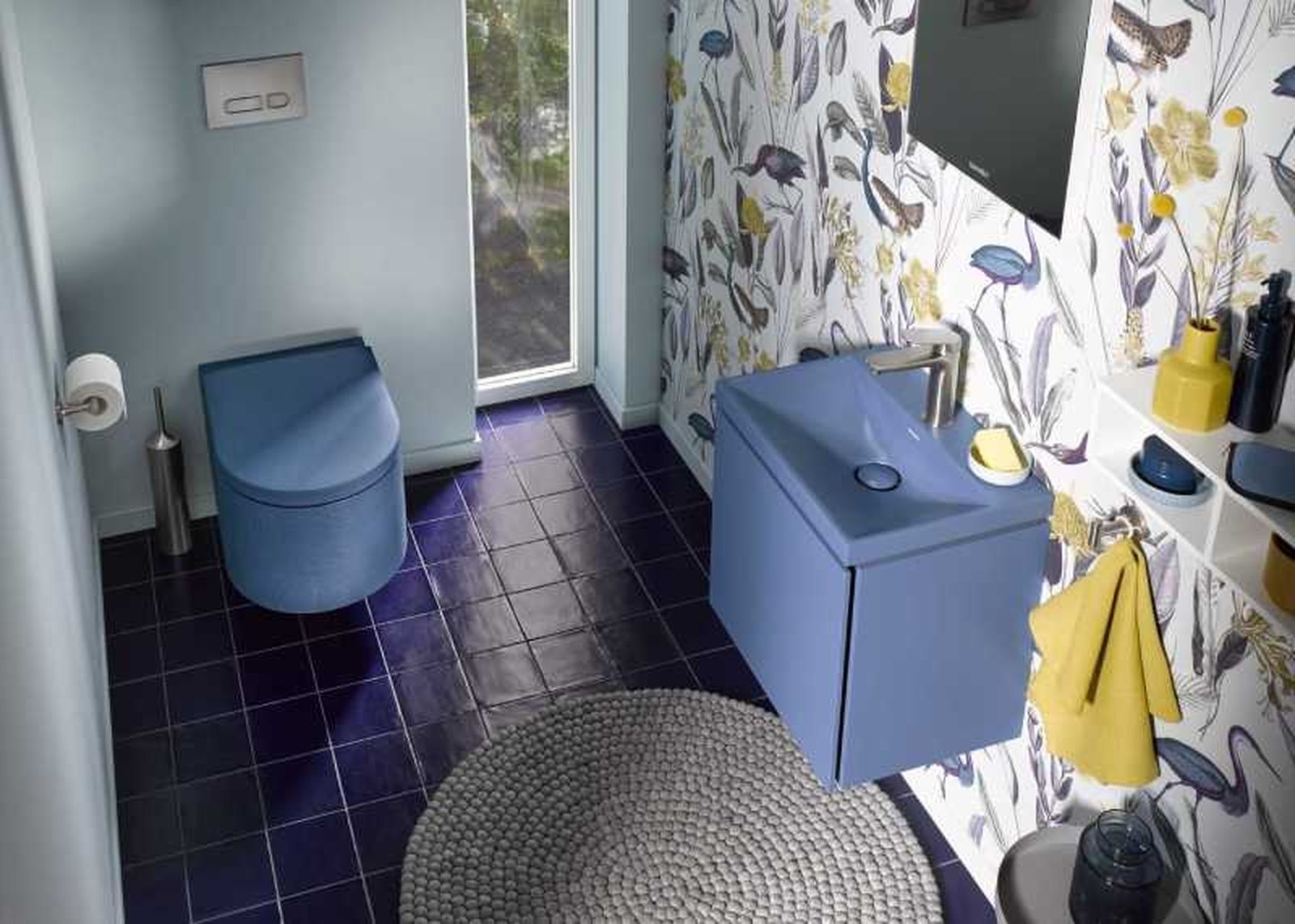 Baño azul con papel pintado y complementos amarillos.