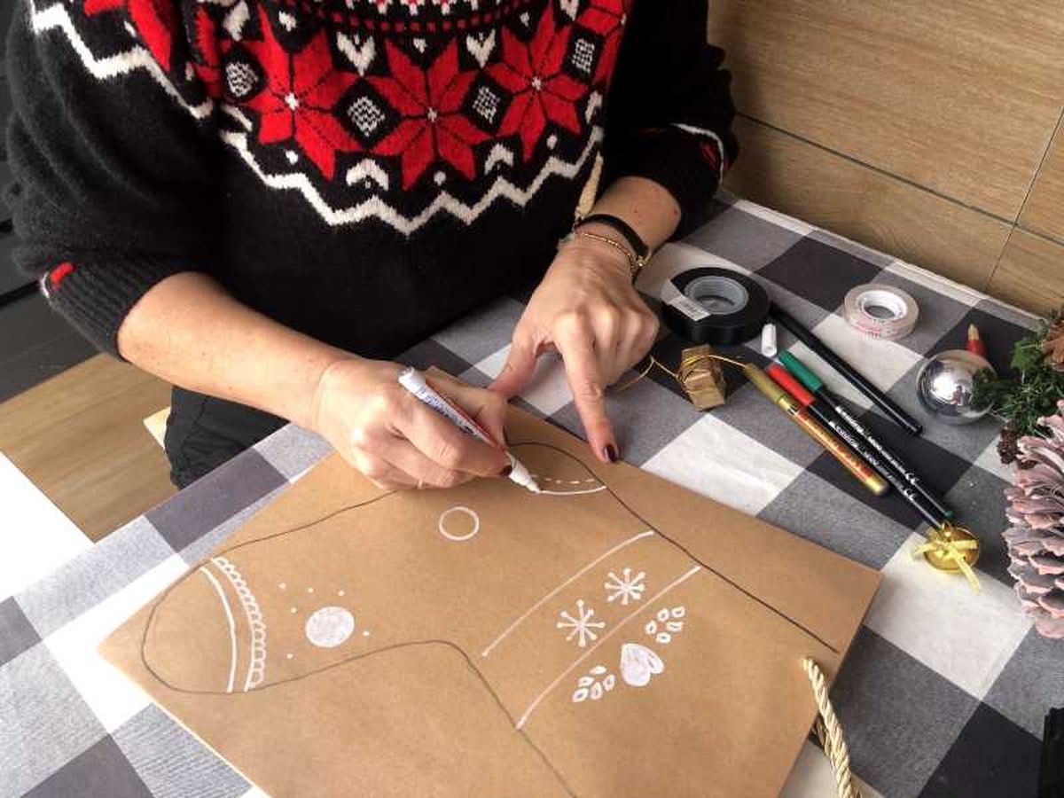 Pinta adornos invernales con rotulador blanco para decorar la bota de Navidad.