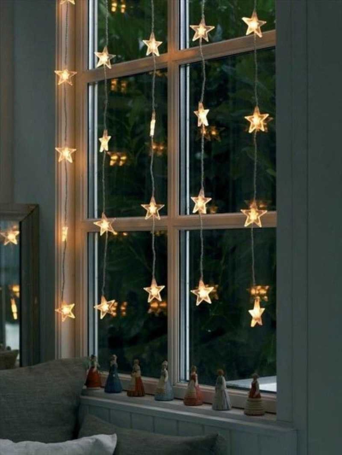 Ventana decorada con cortinas de luces navideñas.