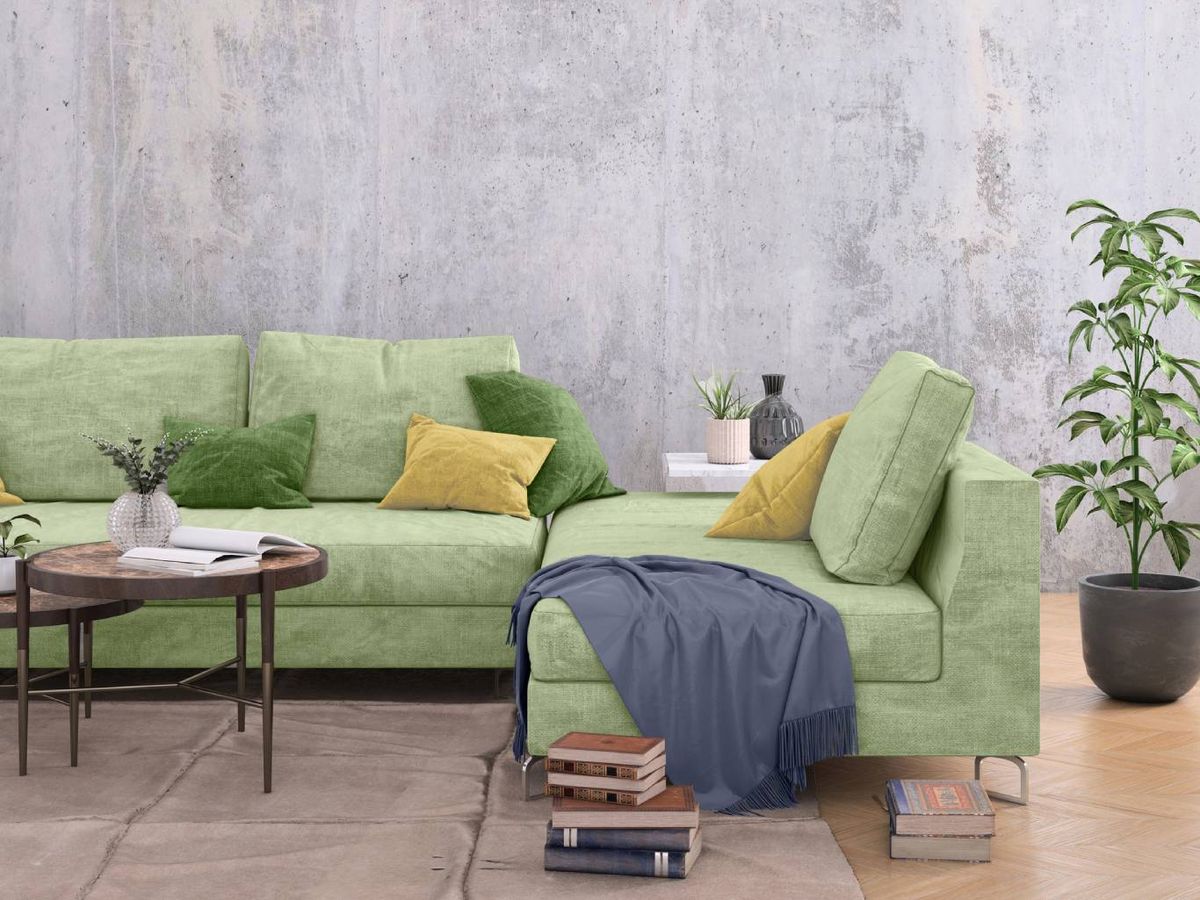 Sofá en verde y hormigón en la pared, una combinación perfecta.