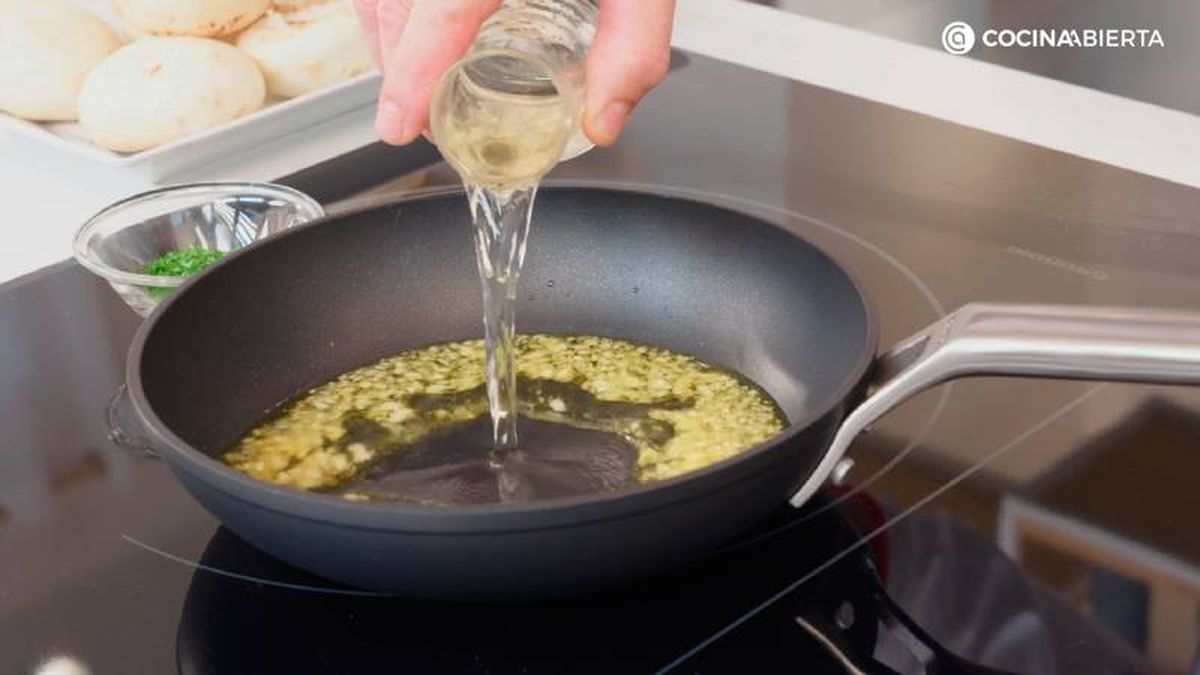 Cocina la salsa de ajo, vino blanco y perejil fresco picado