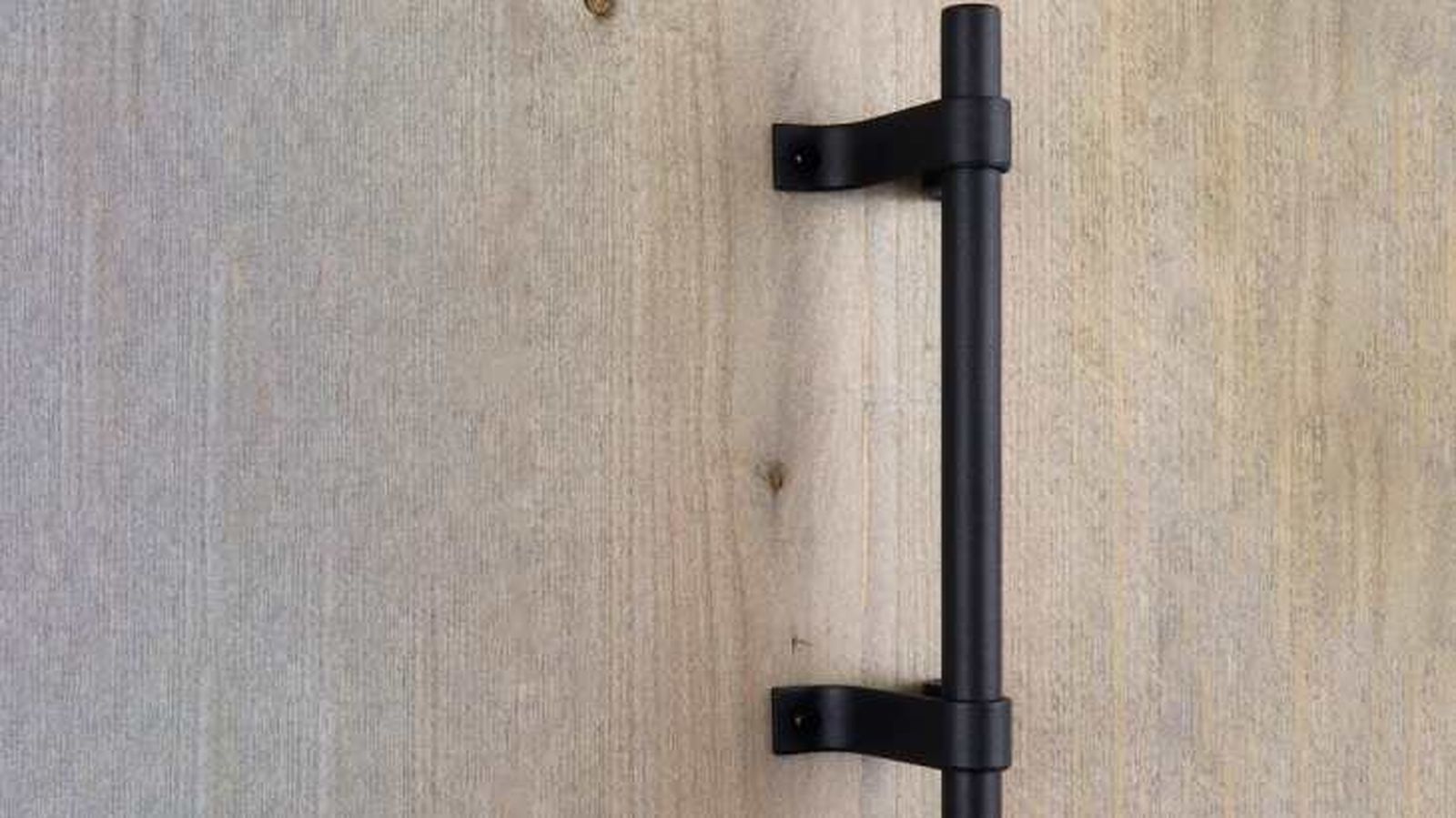 Tirador negro en una puerta de madera