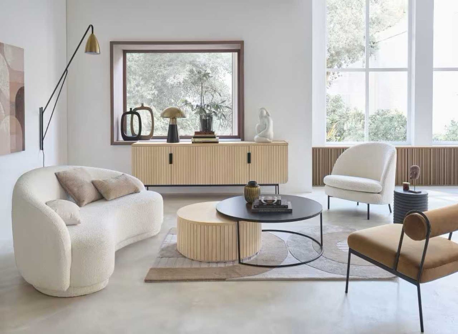 Salón blanco con sofá curvo.