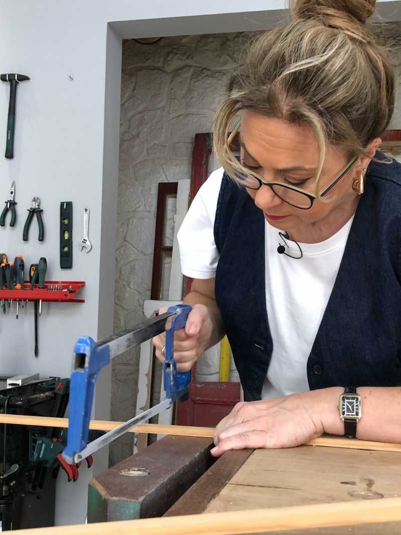Yolanda Alzola cortando los listones para el marco de la televisión.