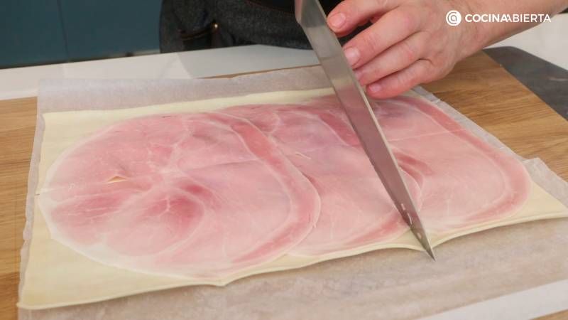 Cubre el hojaldre con jamón cocido y corta en rectángulos