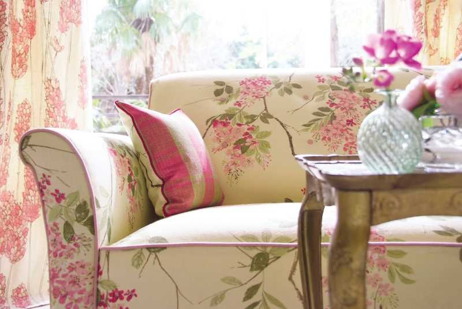 Sofá de estilo vintage con estampado de flores rosas.