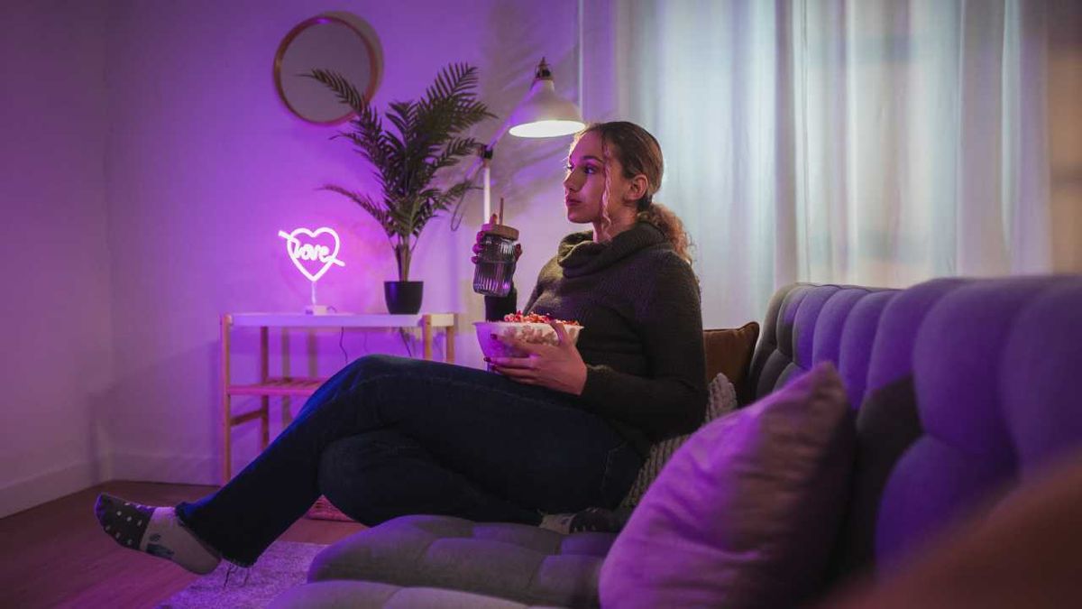 Mujer en un salón con una luz de neón decorativa.