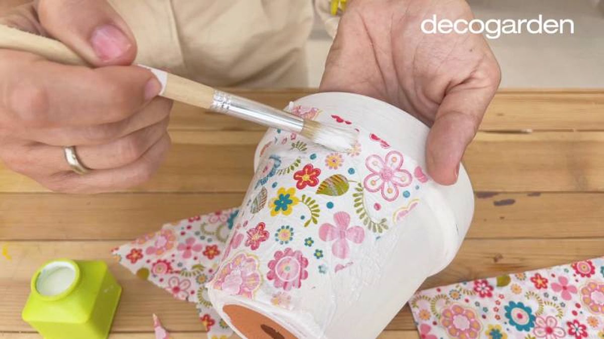 Maceta decorada con la técnica decoupage utilizando papel de estampado floral.