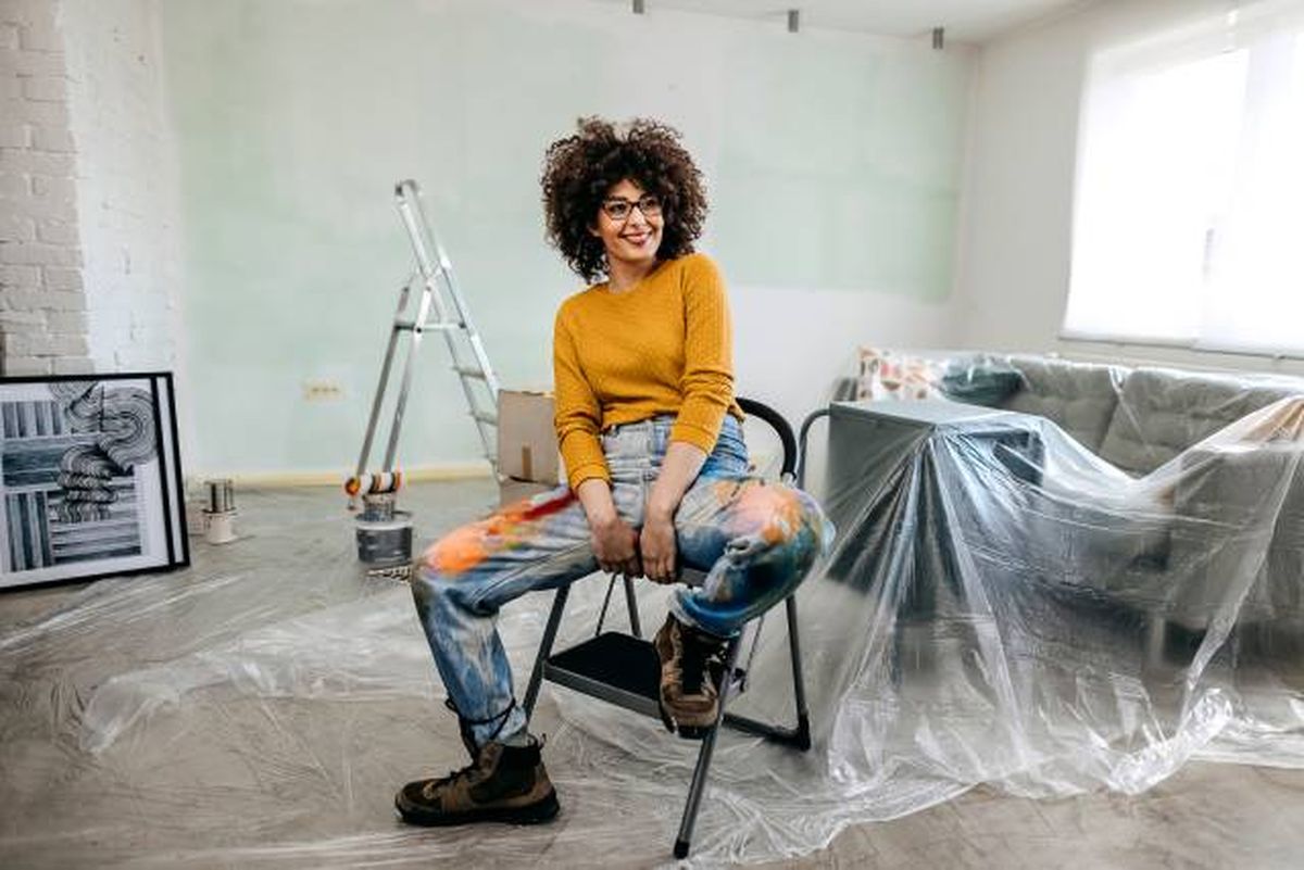 mujer contenta en casa en renovacion de paredes