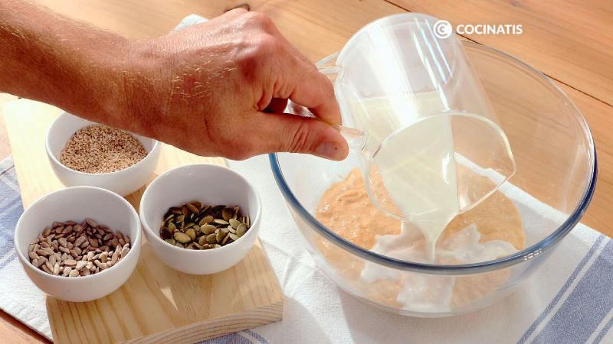 Añade al bol la leche, el sésamo, las pipas de girasol y las semillas de calabaza