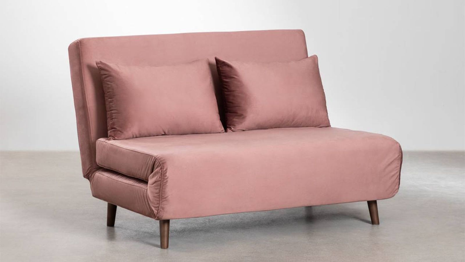 Sofá cama Elen con tapizado de terciopelo en color rosa.
