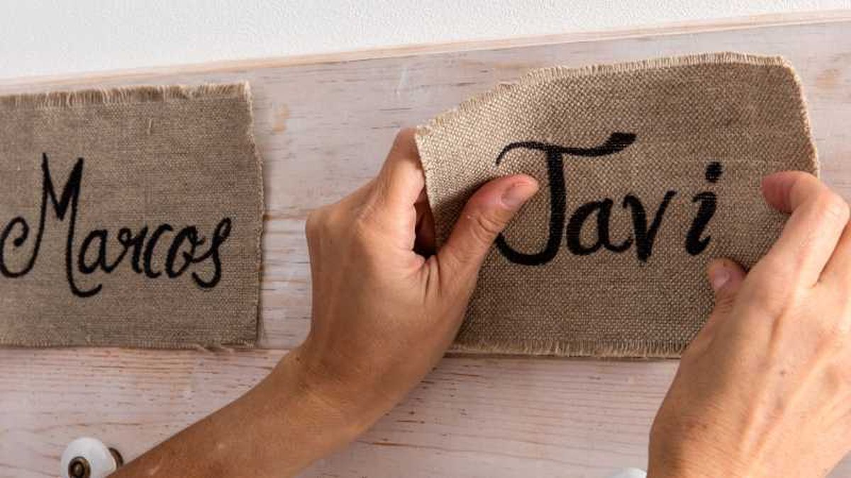 Nombres Marcos y Javi escritos sobre tela de saco para hacer el perchero de Navidad.