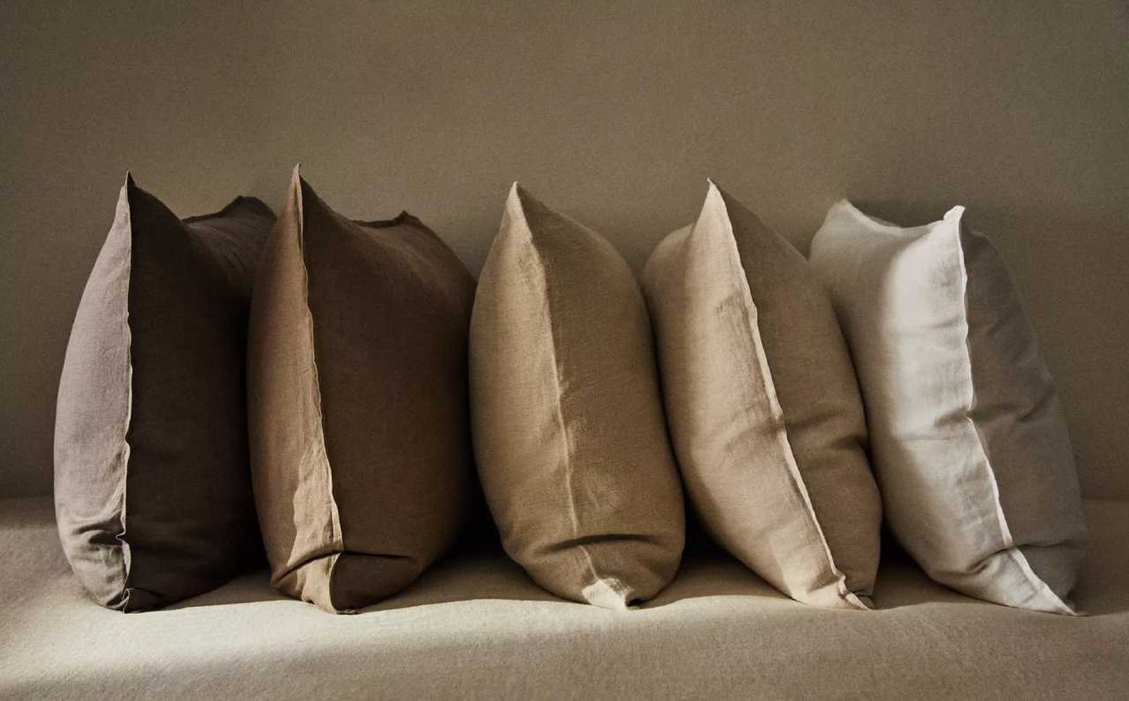 Cojines y fundas de almohada en tonos naturales.