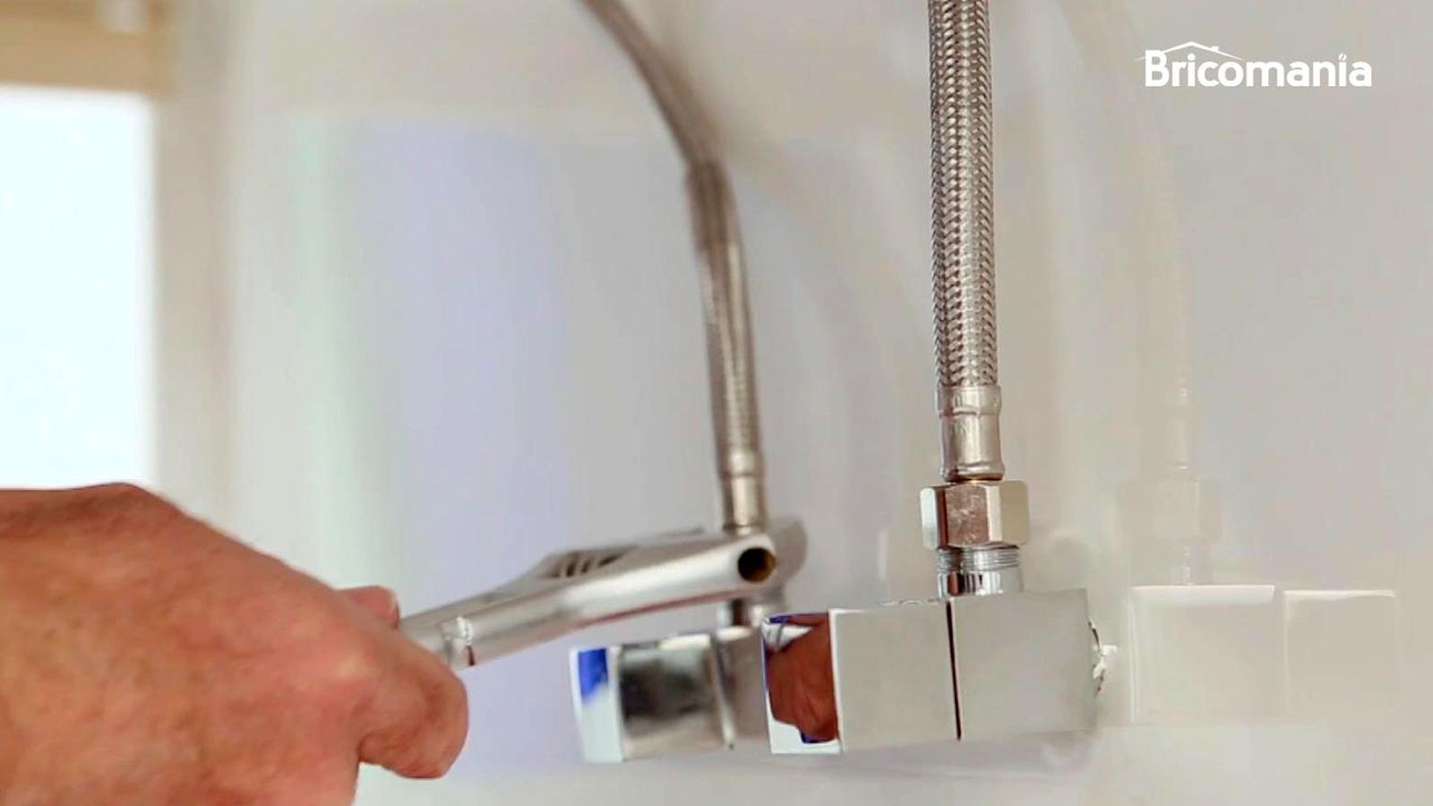 Persona soltando los latiguillos del grifo