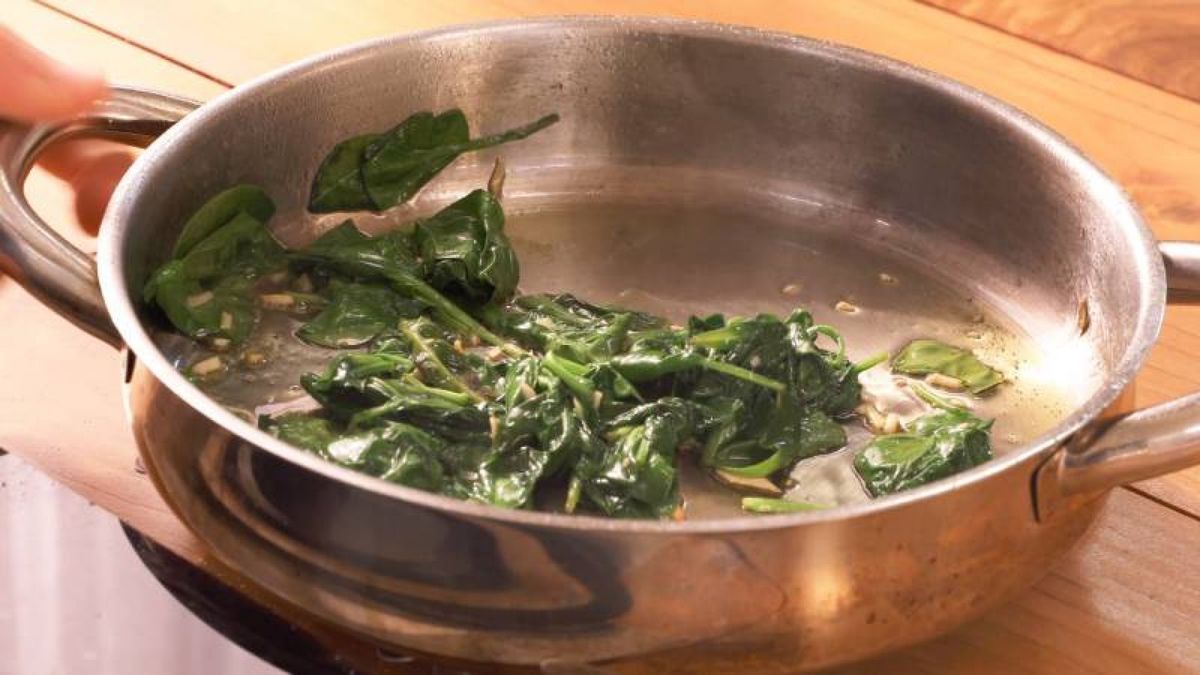Saltea el ajo y las espinacas en un chorrito de aceite para realzar su sabor antes de usarlos en los rollitos de pollo