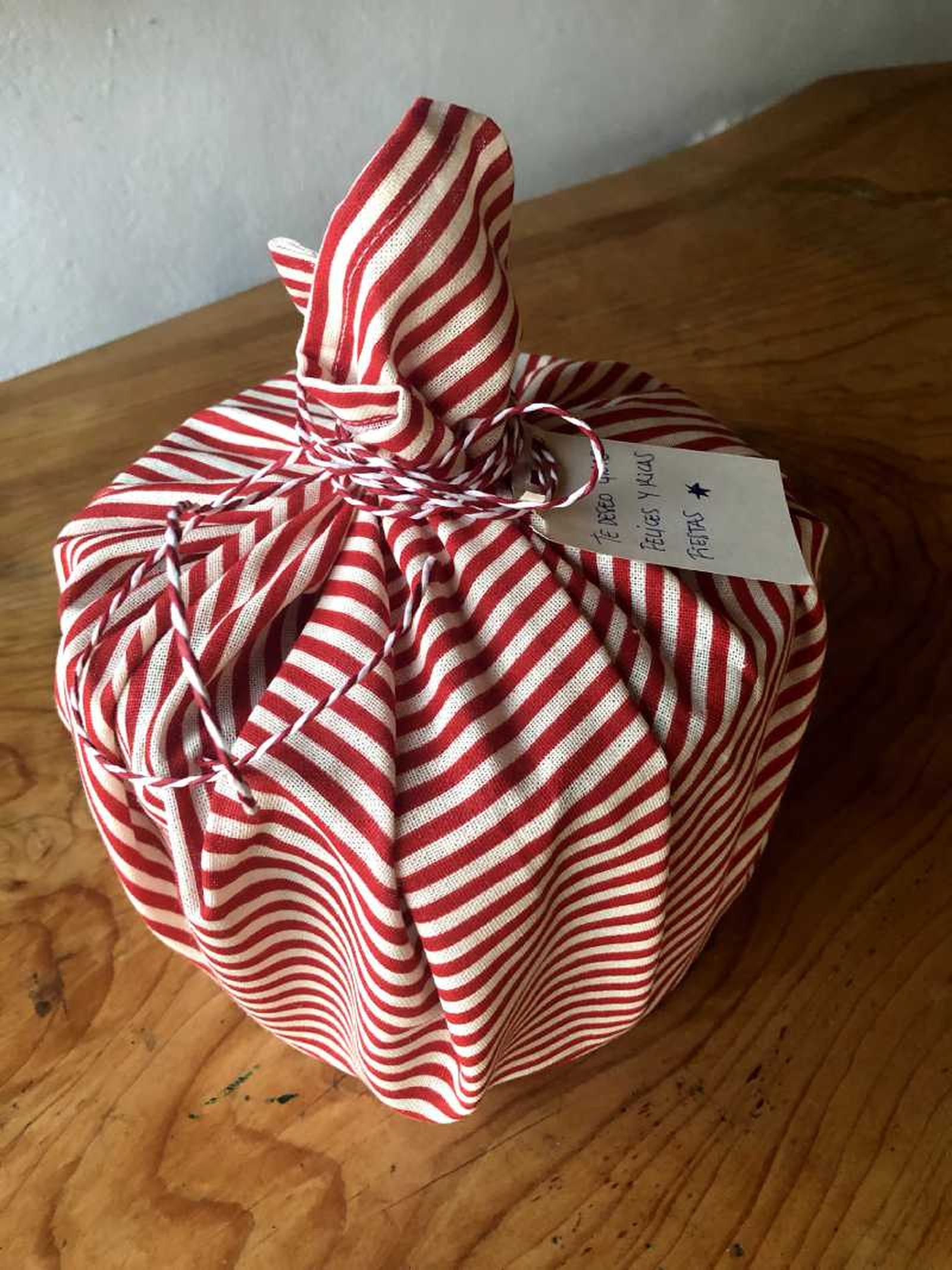 Caja de galletas redonda envuelta en tela furoshiki.