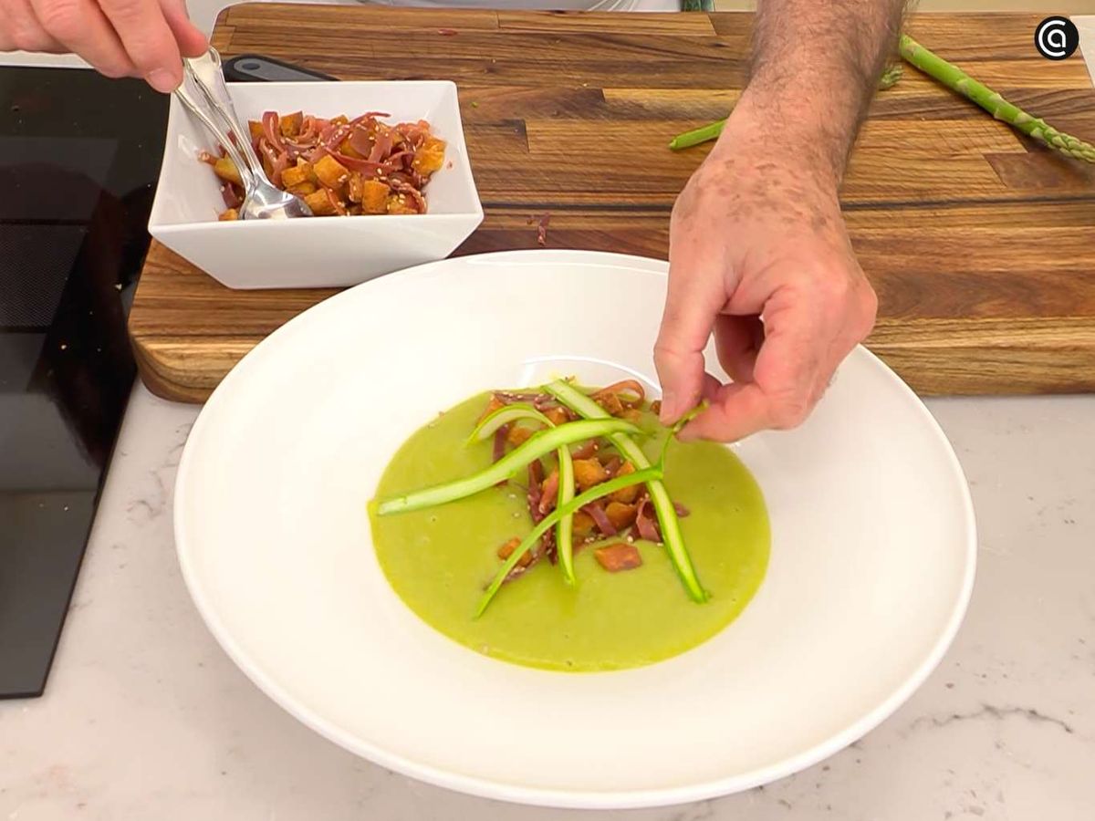 Sirve la crema de espárragos verdes y guisantes