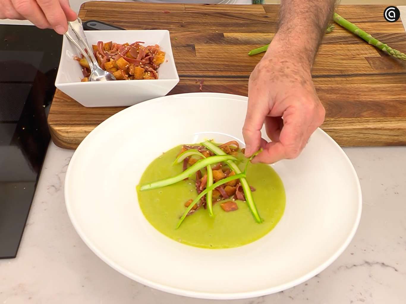 Sirve la crema de espárragos verdes y guisantes