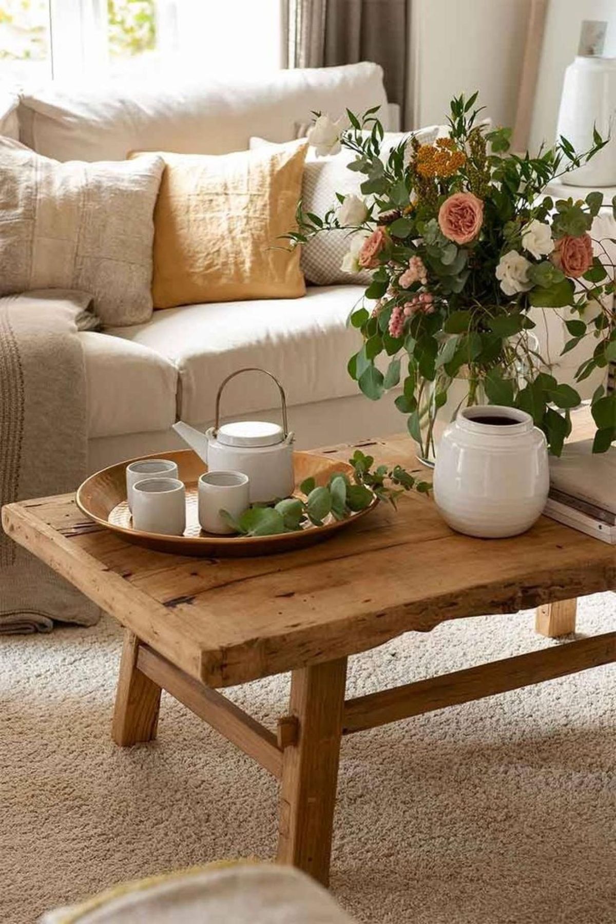Mesa de madera en el salón con decoración primaveral.