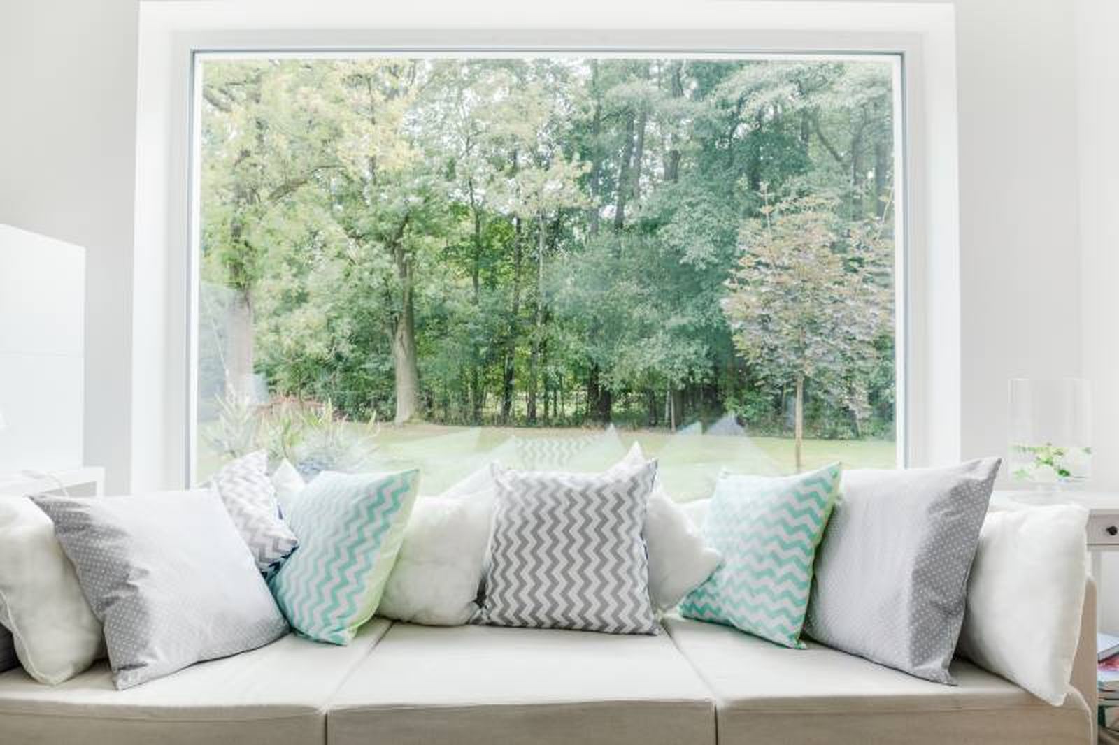 Sofá junto a la ventana con vistas al bosque.