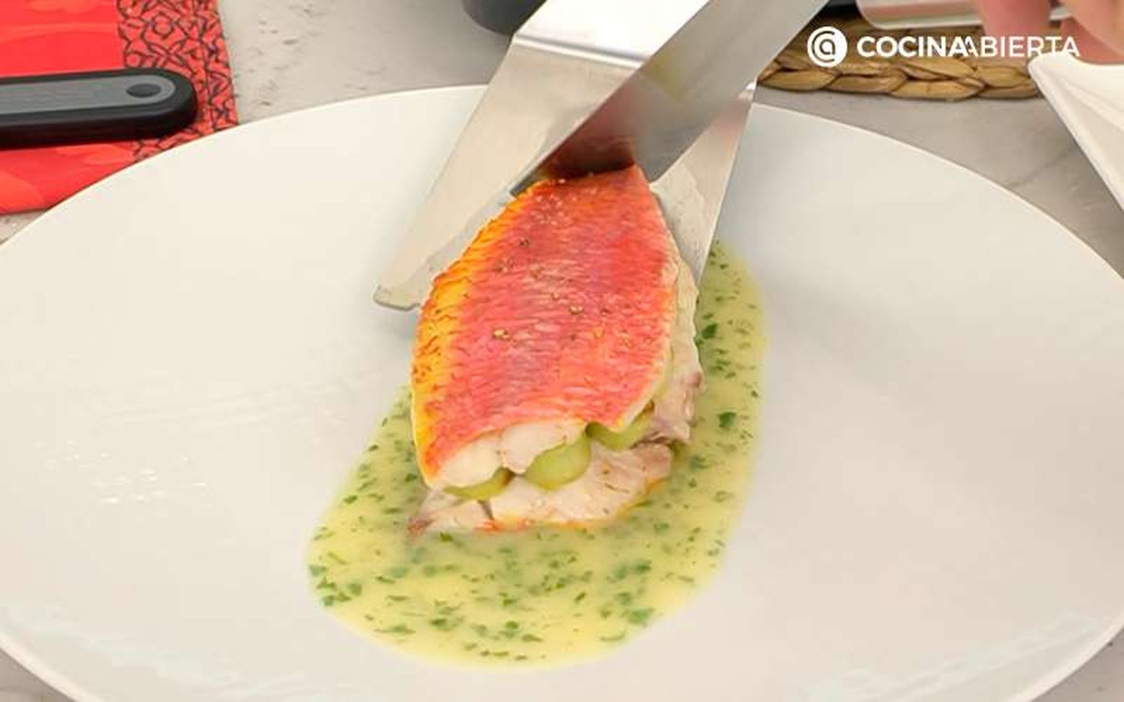 Sirve los salmonetes al horno rellenos de puerros sobre salsa verde