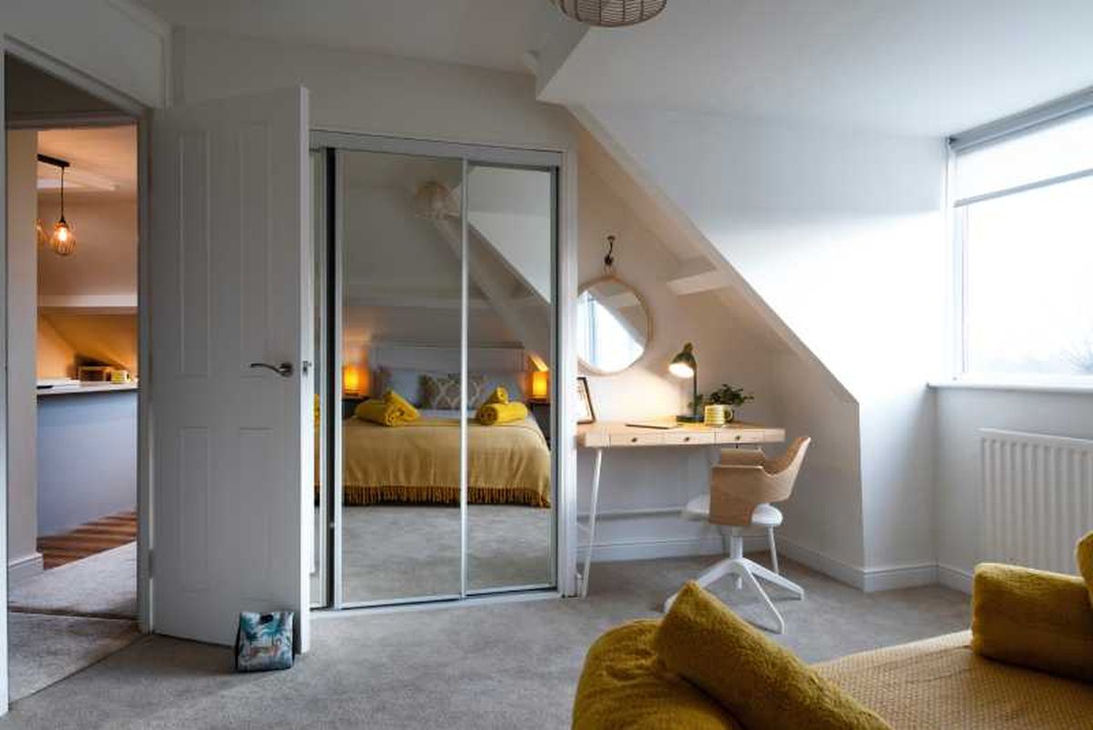 Dormitorio de un estudio pequeño decorado con espejos.