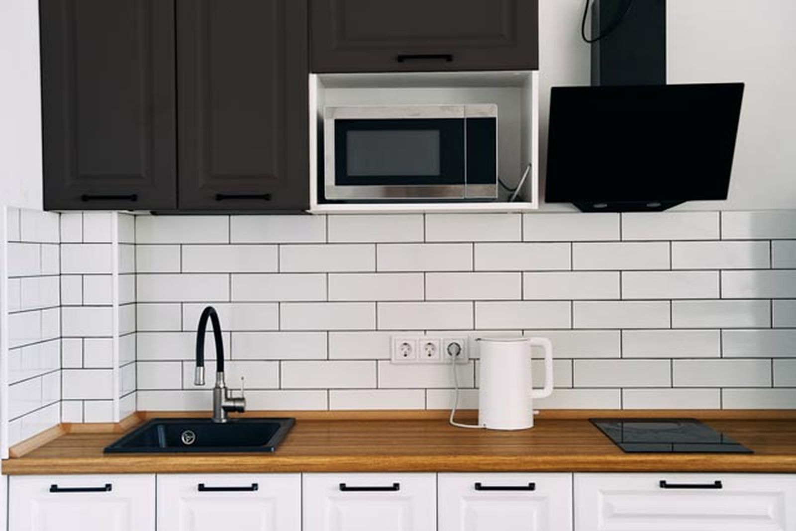 cocina blanca y negra con encimera de madera 2