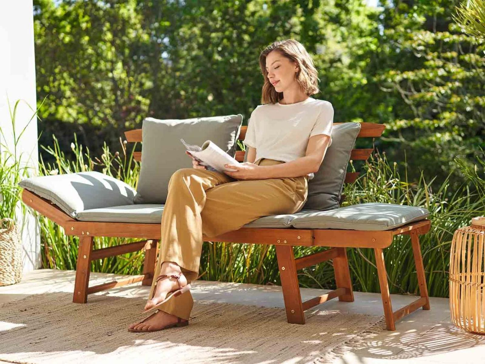 Mujer leyendo en un banco de madera para el jardín.
