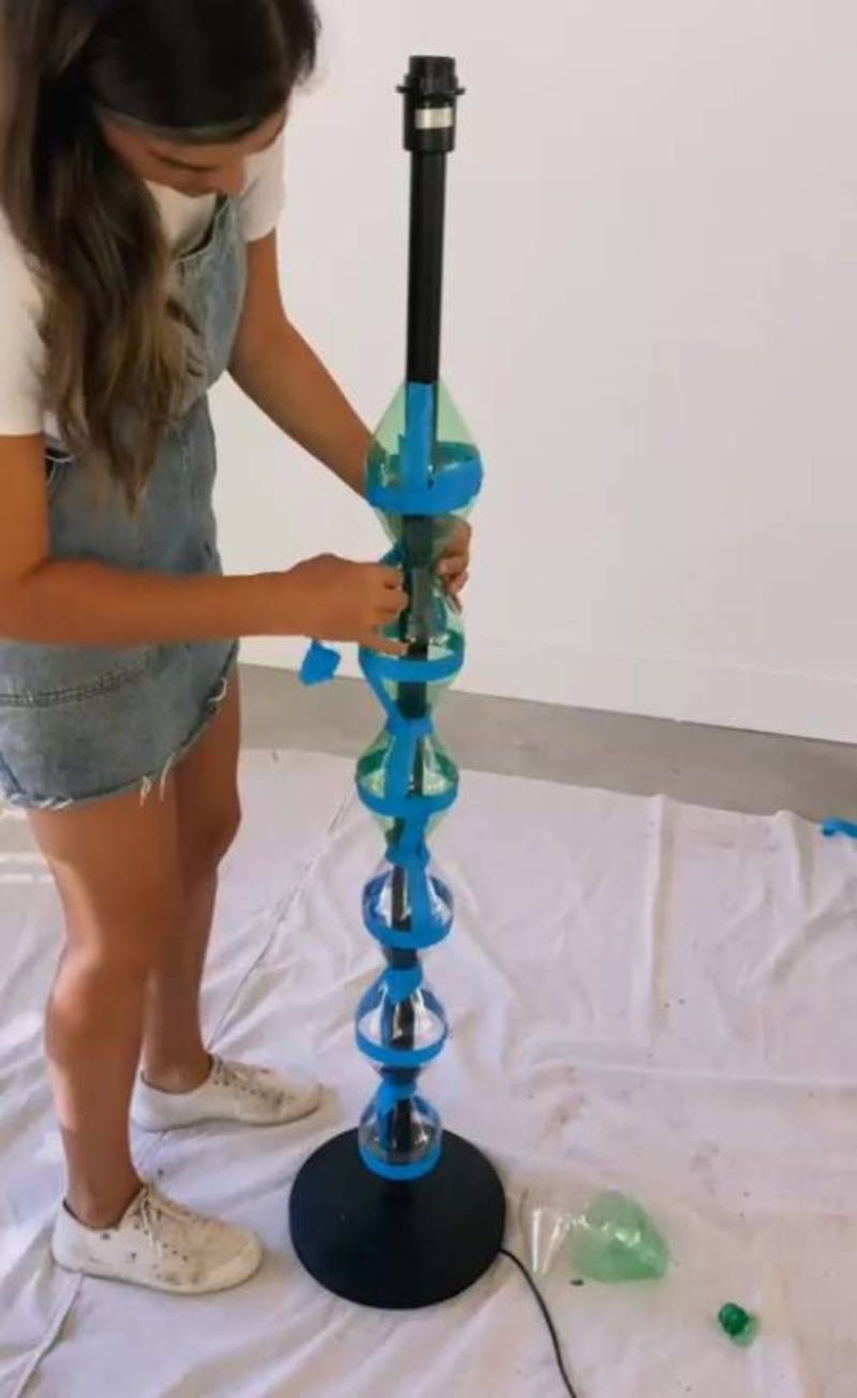 Introducir las botellas de plástico en la lámpara de pie.