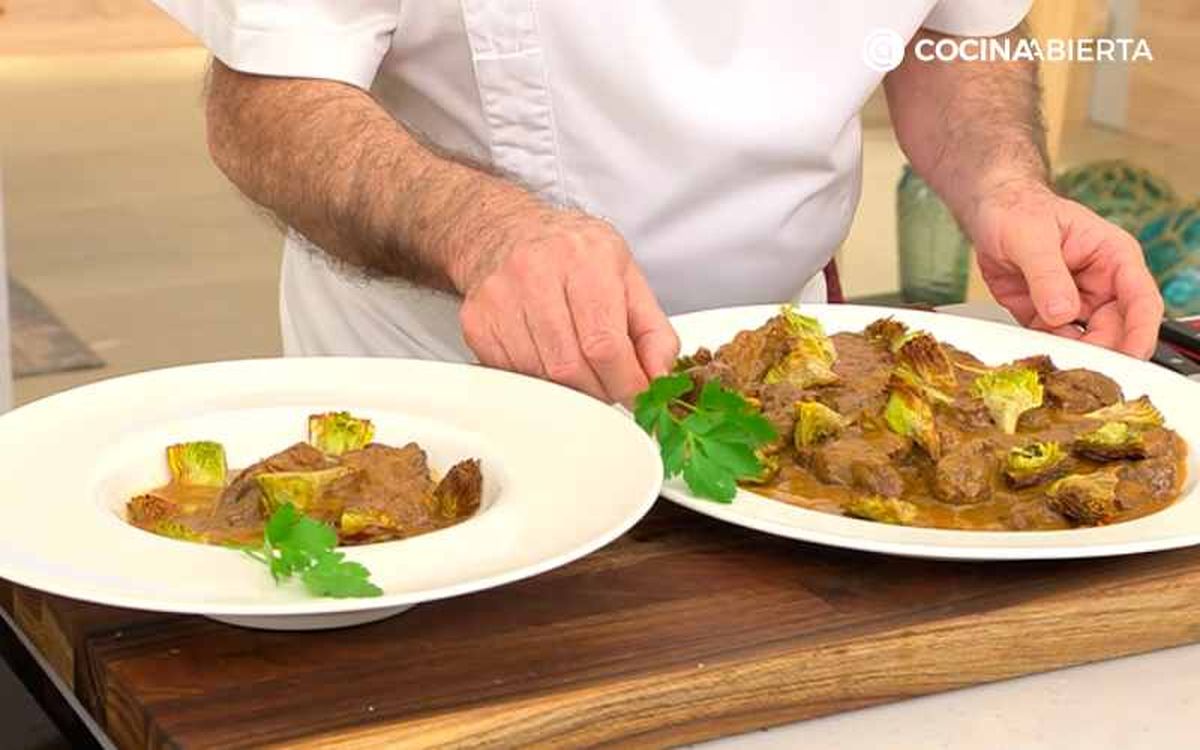 Sirve y decora el morcillo en salsa con alcachofas fritas