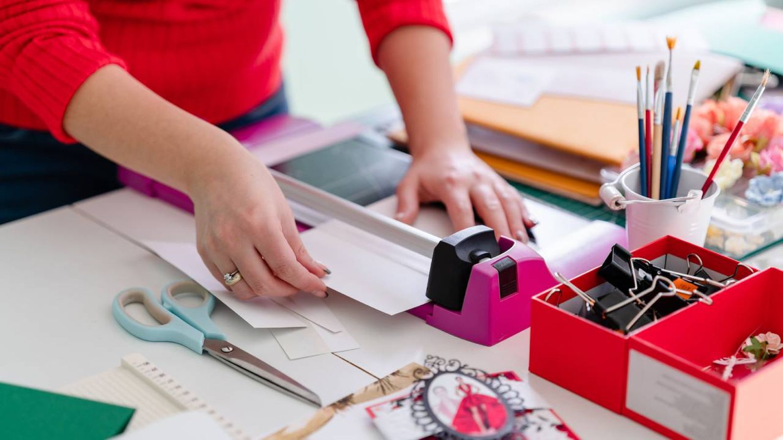 Mujer cortando cartulina para hacer manualidades.