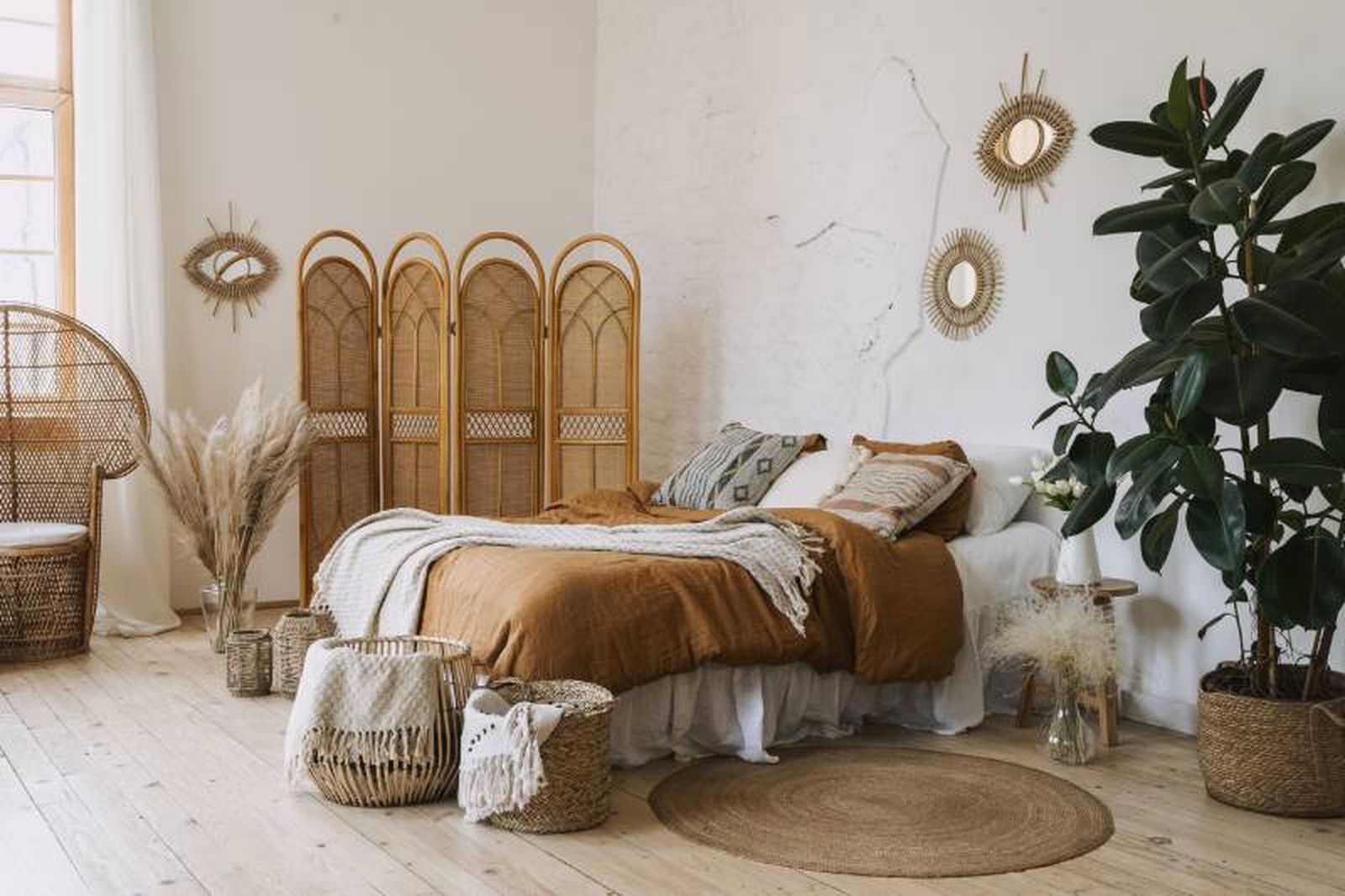 Dormitorio boho moderno con alfombra redonda de fibras naturales.