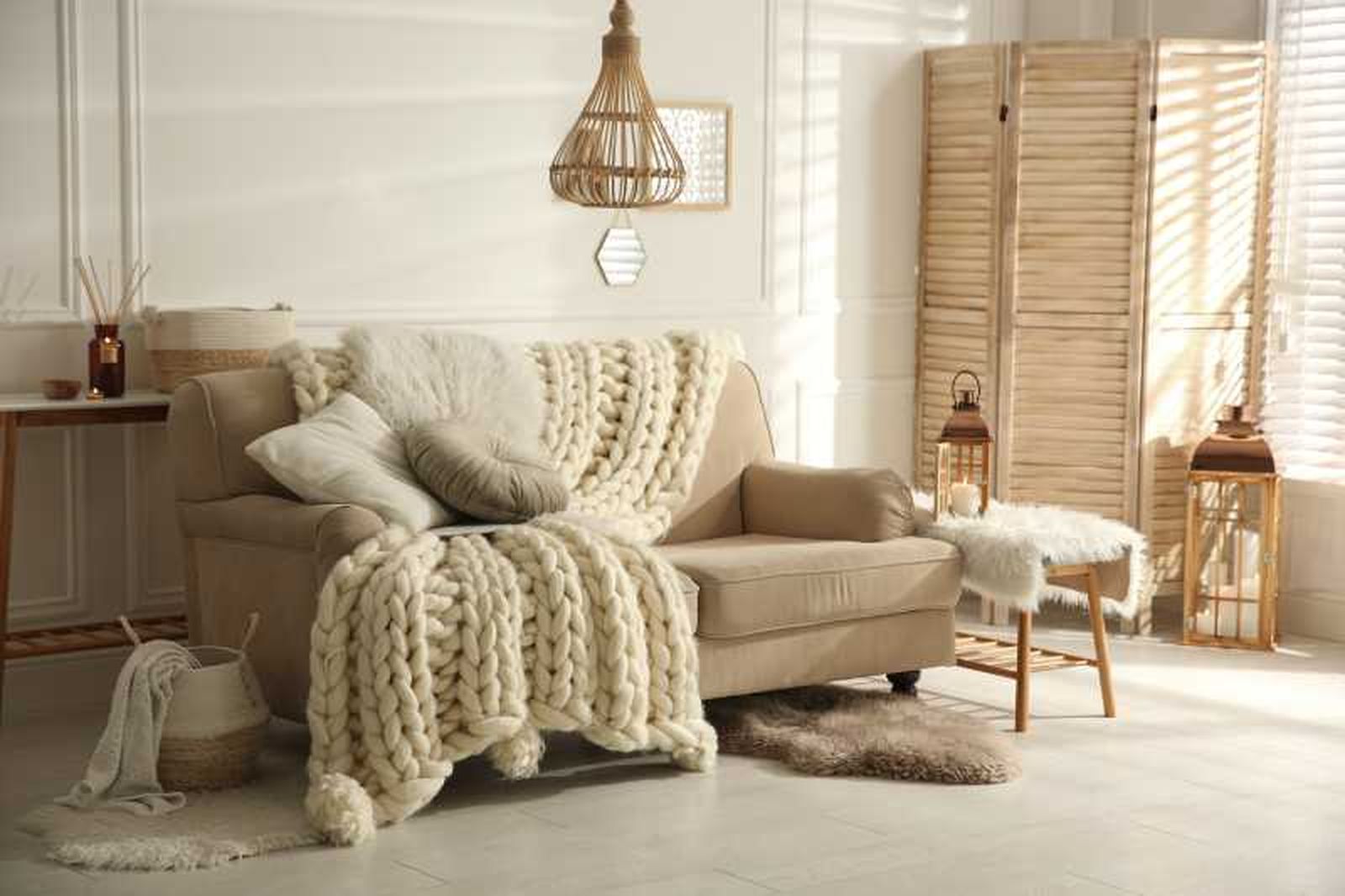 Salón beige con manta de lana gruesa.