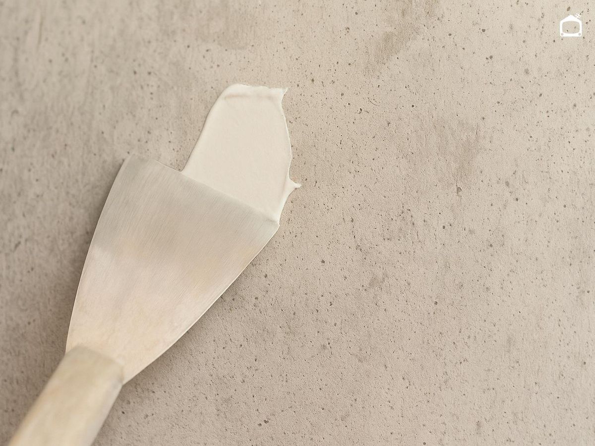 Aplicar masilla en la pared con una espátula.