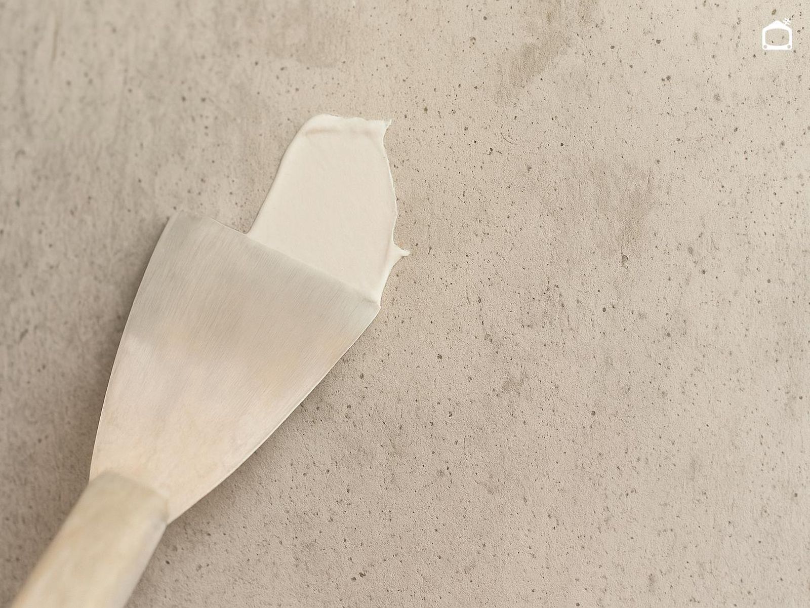 Aplicar masilla en la pared con una espátula.