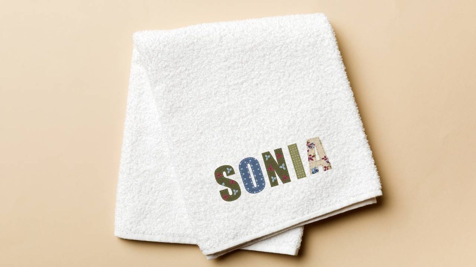 Toalla con nombre en letras patchwork.