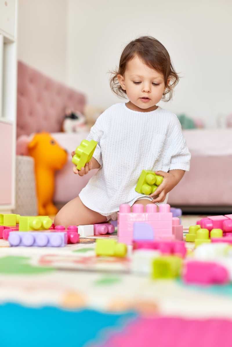 Niña jugando sobre un suelo vinílico infantil.