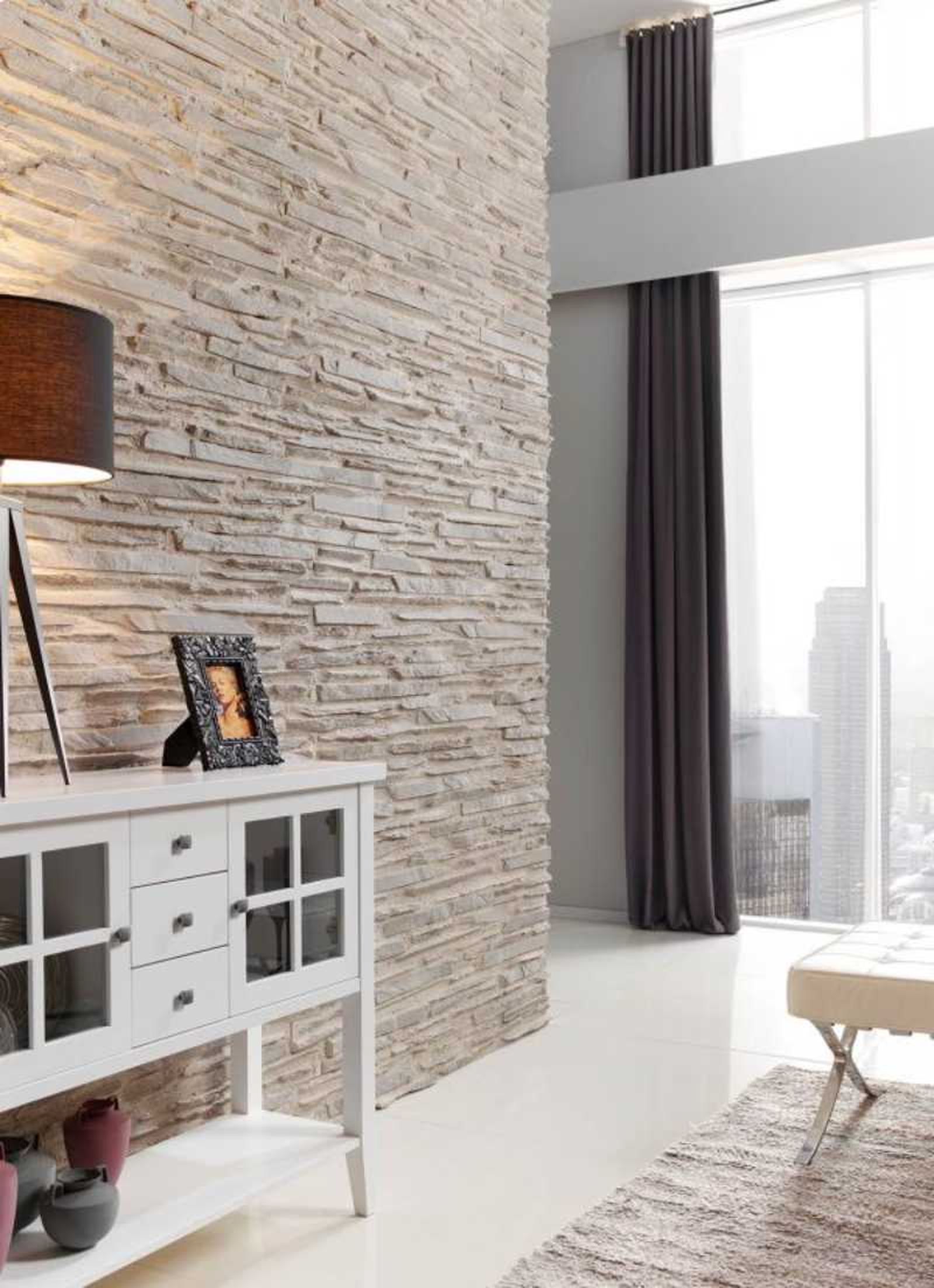Salón con pared decorada con panel de piedra.