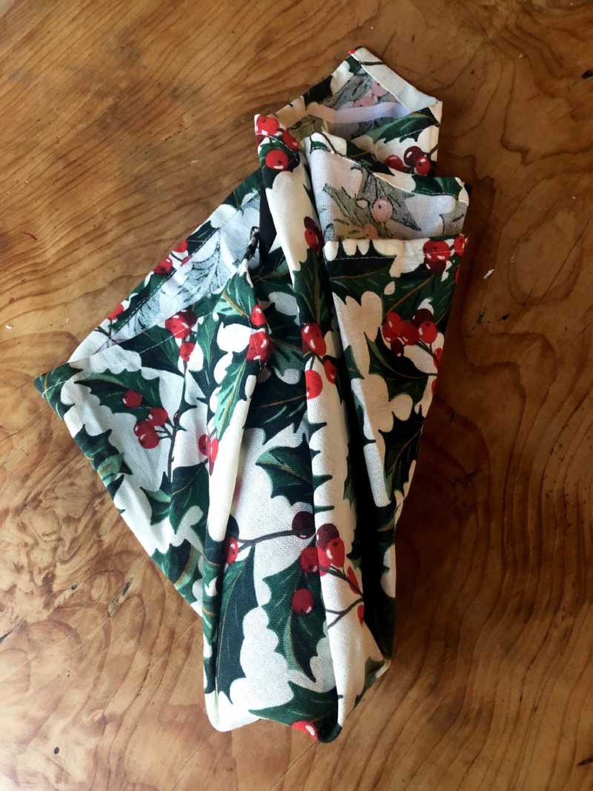 Paso tres para envolver una botella en tela furoshiki.