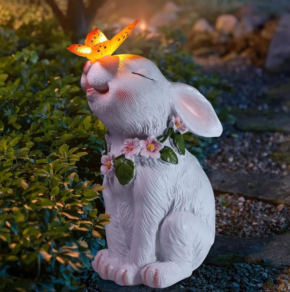 Figura de conejito de jardín con mariposa de luz solar.