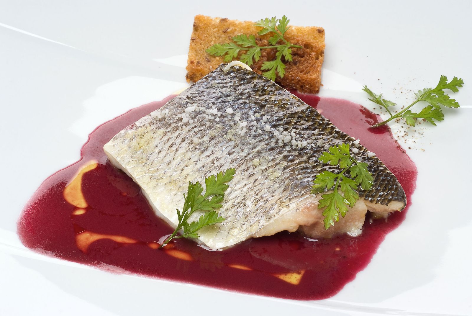 Lubina a 55º con salsa de vino tinto y pan frito