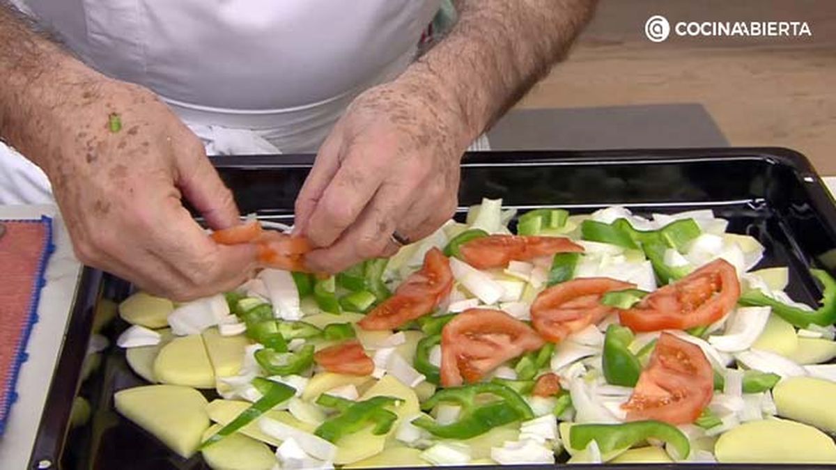 El primer paso es colocar una base de patatas y verduras en la bandeja del horno