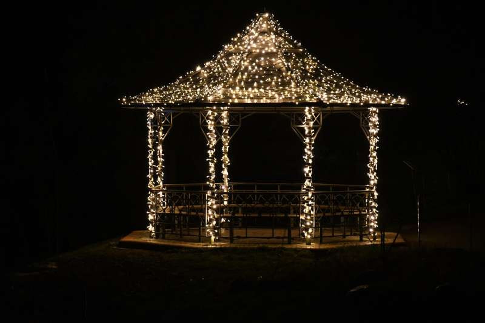Cenador de jardín con iluminación navideña.