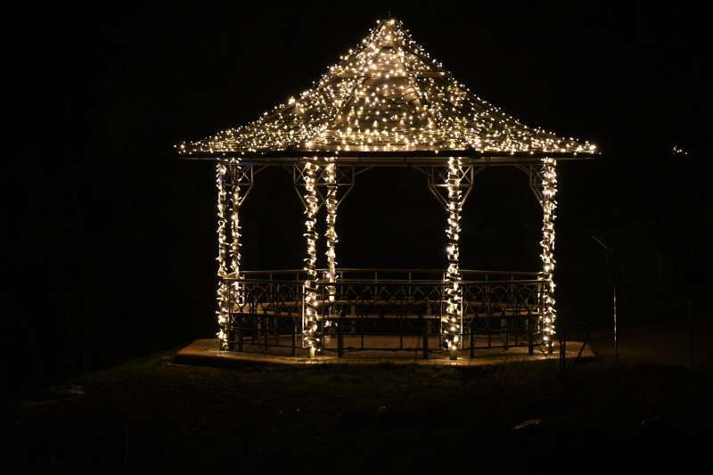 Cenador de jardín con iluminación navideña.