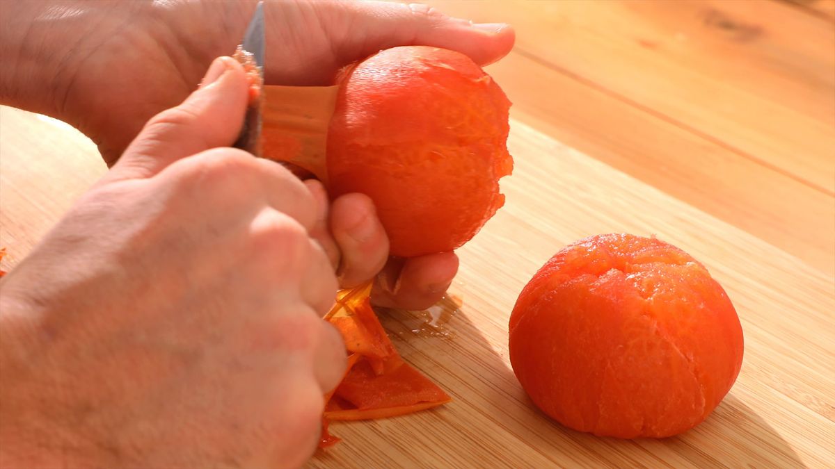Retirar la piel de los tomates y los ajos asados es crucial para lograr una textura suave y un sabor intenso en la salsa romesco