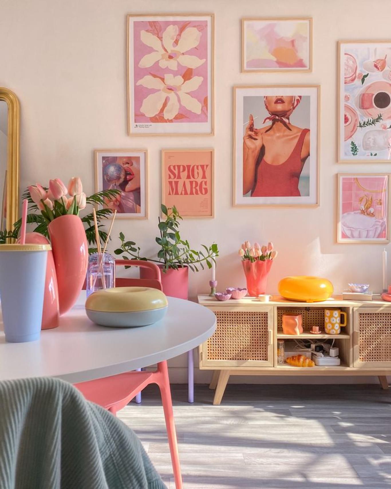 Rincón del salón con la pared decorada con cuadros coloridos.