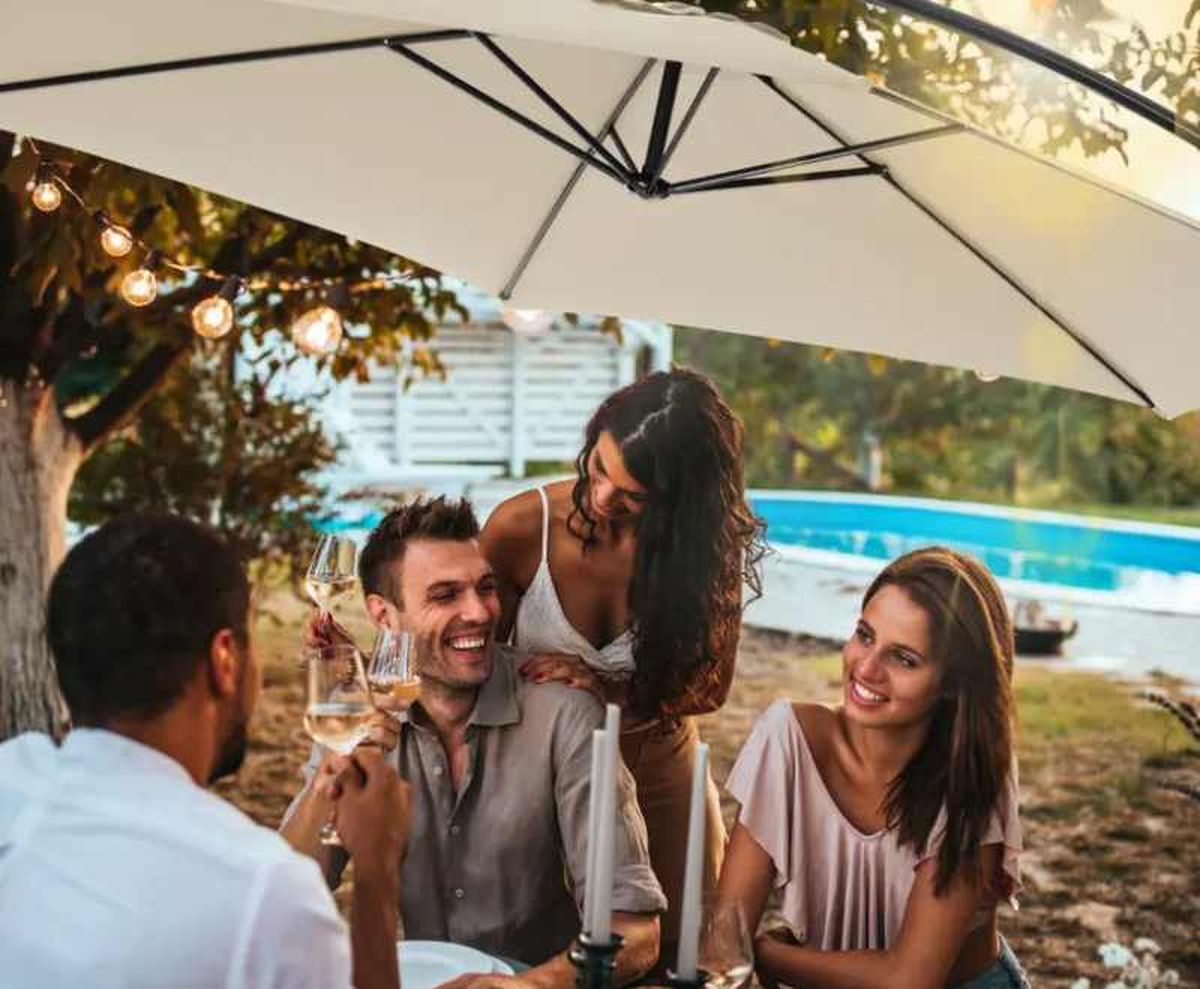 Personas disfrutando del jardín bajo la sombra